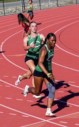 Taryn Gayle hands off the baton to Emeree Dasilva. The girls 4x100M relay won 1st place and advanced to area.